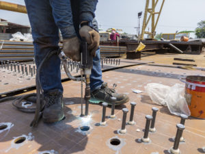 Bolzenschweißen Schweißer schweißt Bolzen auf Baustelle